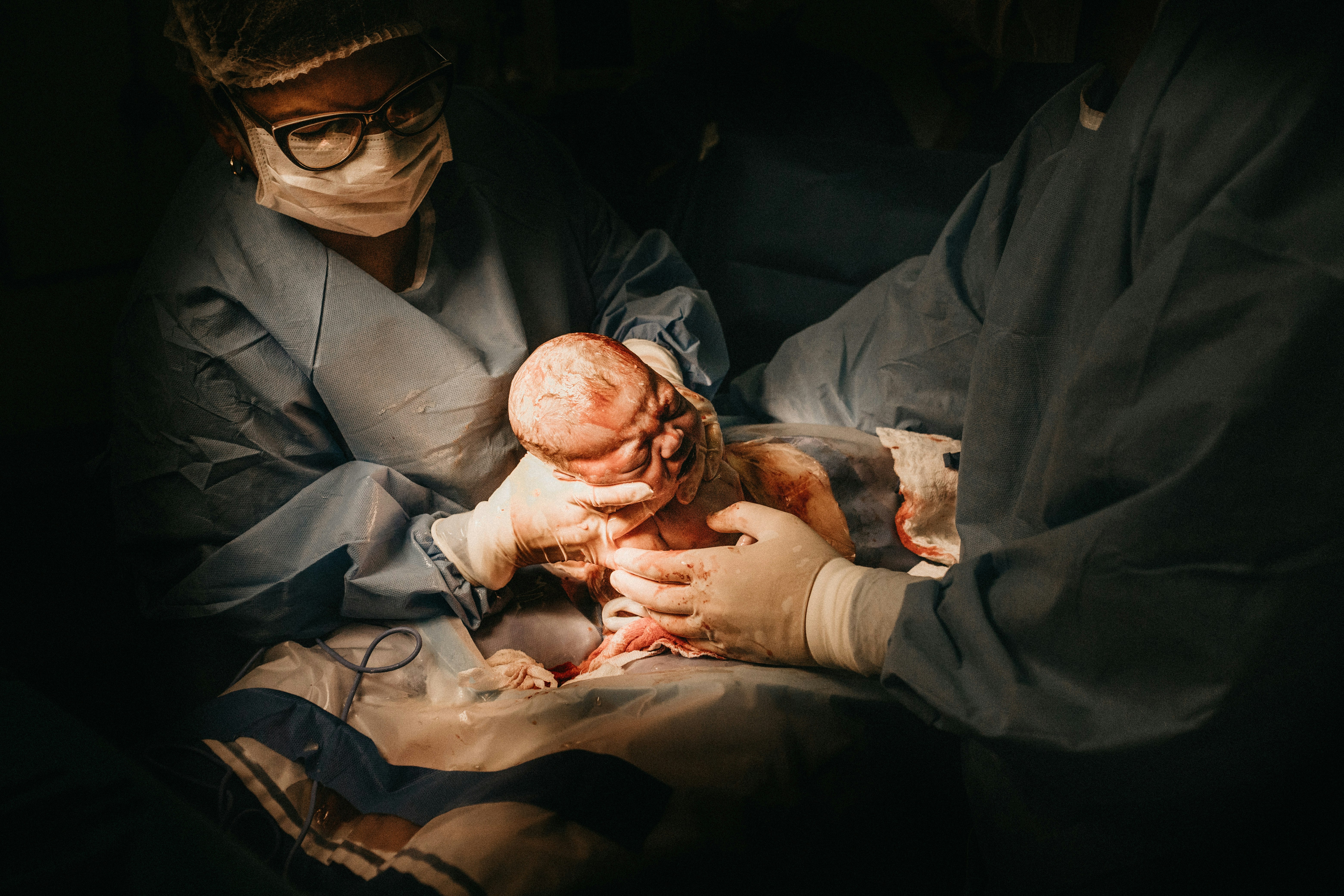 two person holding newborn baby